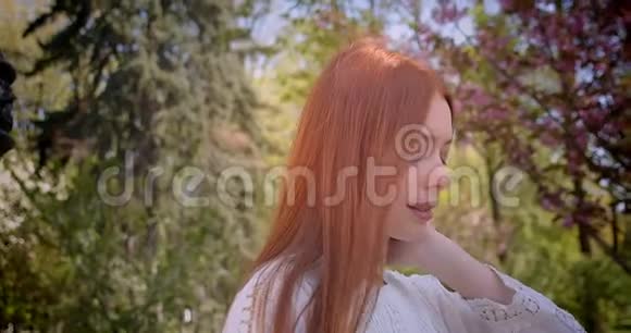 穿着白色短衫的姜姑娘走在粉红色的花园里漂亮地微笑着走进镜头视频的预览图