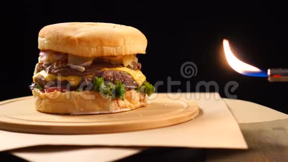 新鲜的开胃汉堡在黑色背景下旋转靠近真正的火视频的预览图