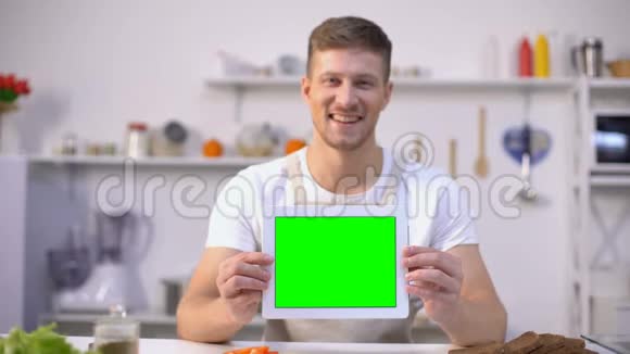 拥有绿色屏幕平板电脑烹饪博客和应用程序模板的开朗男人视频的预览图