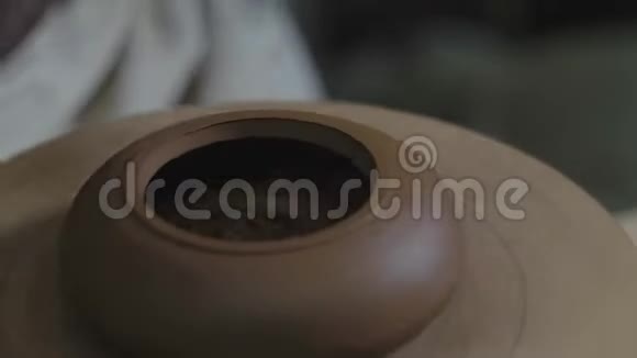 陶工用木轴上的金属抹子从宜兴粘土上加工茶壶茶叶手工粘土茶壶视频的预览图