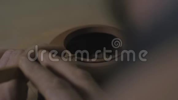 一位工匠用木刀从宜兴粘土中倒角一个茶壶手工陶土茶壶用于茶道棕色陶器茶壶视频的预览图