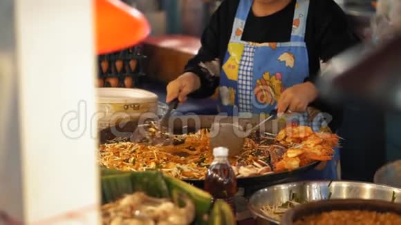 在一个大锅上煮一个美味的泰国垫慢动作厨师在夜市做亚洲街头的食物视频的预览图
