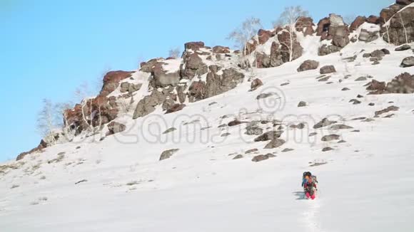 一个大雪覆盖的大山坡脚下有一群旅行者他们准备一起爬上去视频的预览图