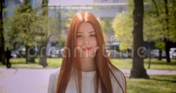 红发女孩走近镜头在绿色公园里真诚快乐地微笑着走进镜头视频的预览图