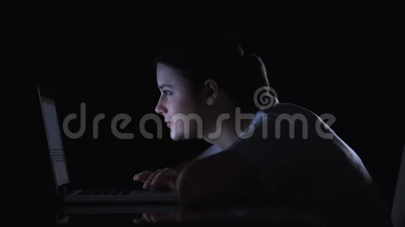 女孩在笔记本电脑上滚动社交网络微笑着阅读帖子和信息视频的预览图