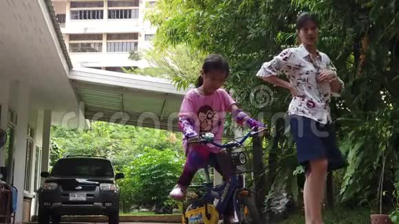 母亲教孩子在家骑自行车视频的预览图