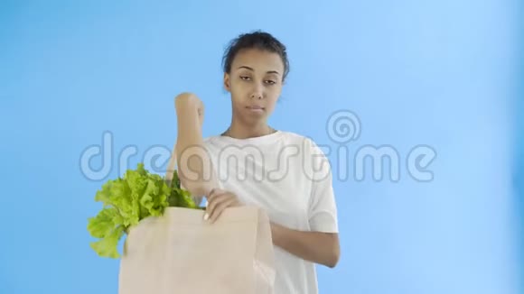 女人拿着蓝底蔬菜包视频的预览图