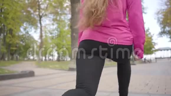 女性高加索腿的特写镜头做步行弓箭步年轻女运动员上午在秋园训练视频的预览图
