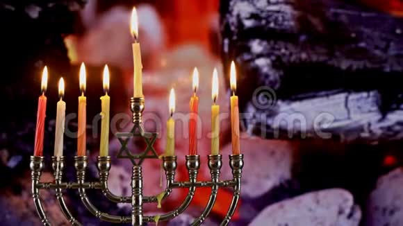 犹太节日光明节与menorah传统的燃烧蜡烛火燃烧在壁炉煤火中视频的预览图