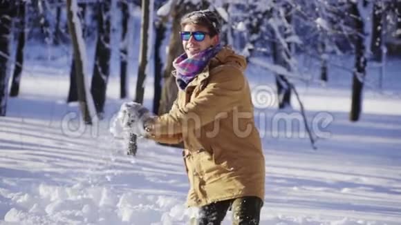 快乐的年轻人在镜头前缓慢地扔雪冬天的心情冬季体育假日圣诞节视频的预览图