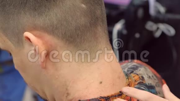 理发师用锋利的剃刀剃男人脖子上的头发造型师的手特写视频的预览图