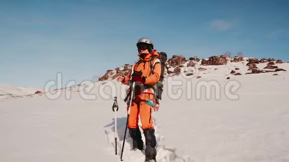 雪中有滑雪杆的女登山者望着旁边挺直了眼镜欣赏着雪景视频的预览图