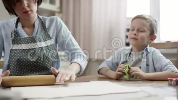 妈妈用不同的方法在厨房的桌子上和孩子们一起做饼干视频的预览图