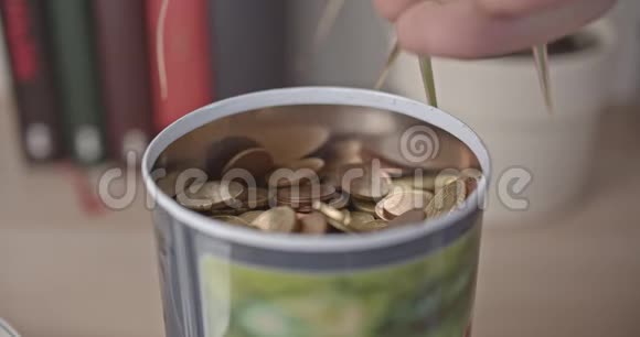 男性手把欧元硬币倒入罐子里视频的预览图