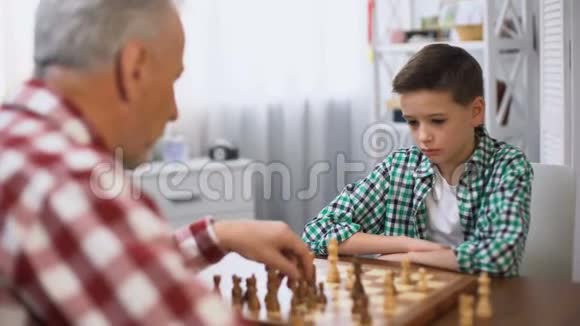 小男孩和祖父下棋家庭传统心智发展视频的预览图