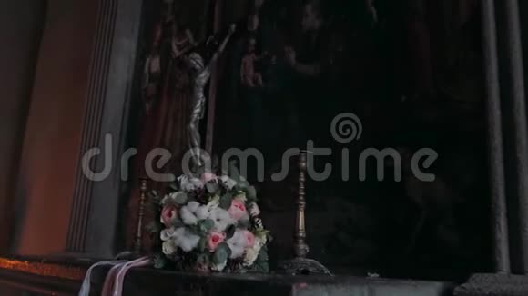 一束鲜花躺在耶稣的雕像旁视频的预览图