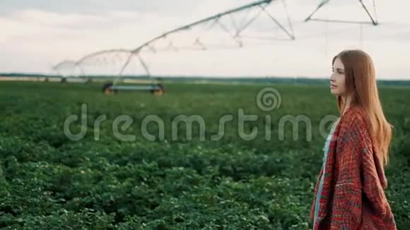 穿着老式连衣裙的年轻农民女孩走过田野农产品种植有机产品概念农业视频的预览图