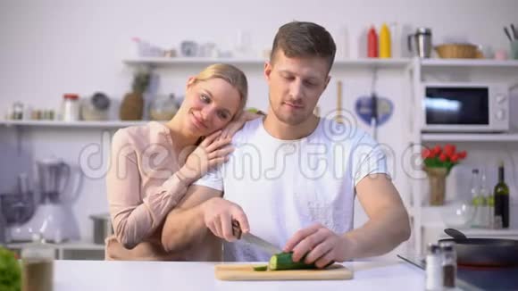 丈夫切菜爱人拥抱他厨房浪漫时刻视频的预览图