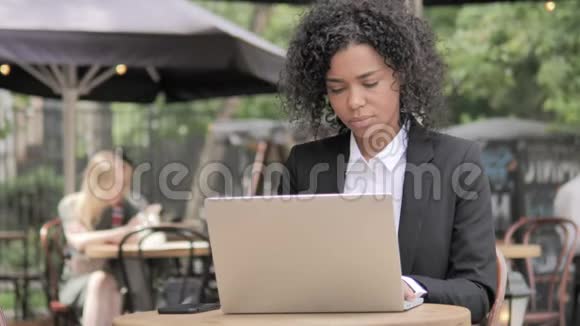非洲女商人颈部疼痛使用笔记本电脑户外视频的预览图
