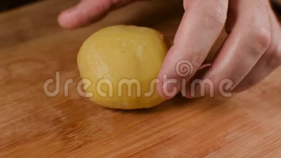 切煮土豆女性的手正在用一把大刀在一块木头砧板上切煮土豆特写视频的预览图