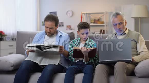 爸爸和儿子读书看报纸老人拿着笔记本电脑几代人视频的预览图