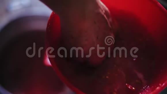 一位老年妇女将番茄推入机械榨汁机的特写镜头视频的预览图