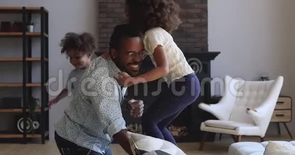 快乐的非洲爸爸和活跃的孩子在家玩得开心视频的预览图