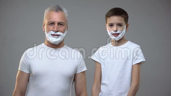 快乐的老人和小男孩在剃须泡沫交叉双手在胸前有趣视频的预览图