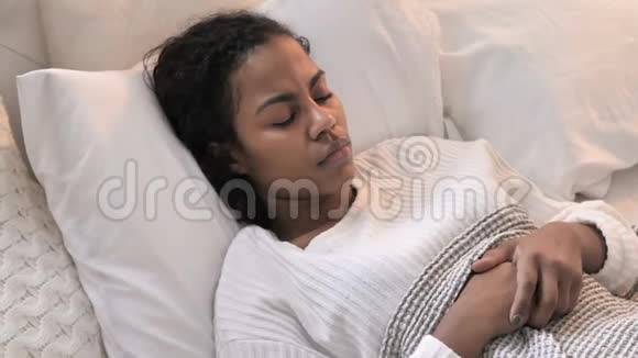 生病的非洲年轻妇女在床上咳嗽的最高看法视频的预览图
