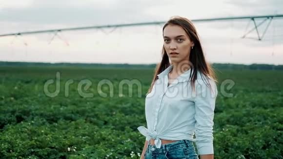 一个穿短裤的年轻农民女孩走过田野农产品种植有机产品概念A视频的预览图