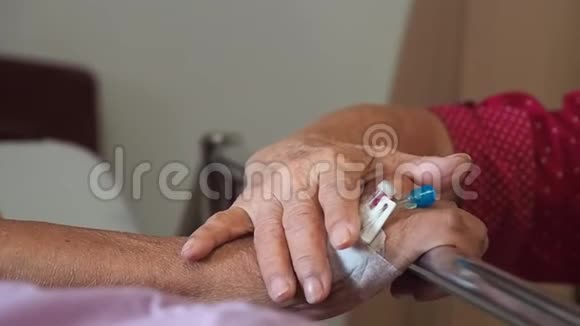 妻子在医院探望丈夫这对老夫妇牵着双手躺在病床上住院治疗以支持他亲爱的视频的预览图