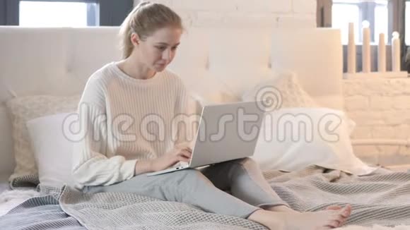 令人惊讶的年轻女子在床上笔记本电脑的结果视频的预览图