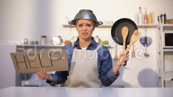 没有经验的家庭主妇在做饭时寻求帮助头上戴着锅开玩笑视频的预览图