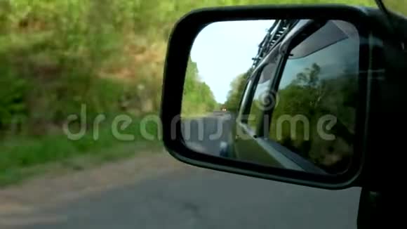 在土路上拍摄移动汽车的镜子视频的预览图