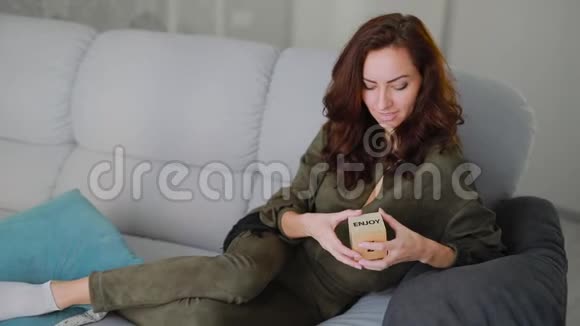 美丽的黑发女人拿着一个字欣赏的立方体视频的预览图