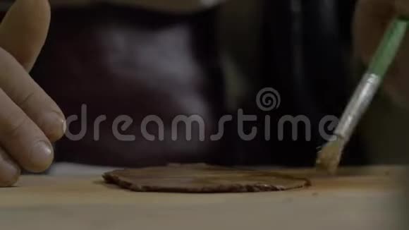 陶工用刷子湿润粘土然后用专用木锤将其击退宜兴茶叶手工陶壶视频的预览图