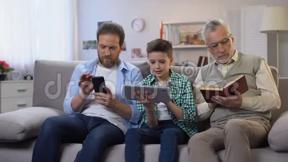中年男性和青春期前的男孩滚动小工具老年人阅读纸质书视频的预览图