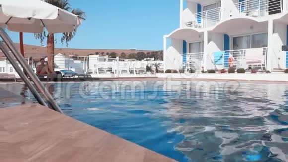 少女戴护目镜游泳池水在避暑胜地在度假酒店的游泳池里漂浮的年轻女孩视频的预览图