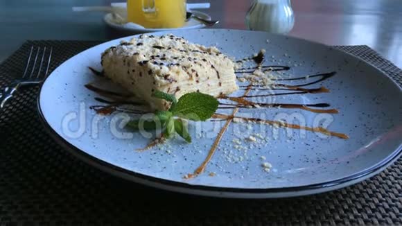 美味的甜点拿破仑奶油蛋糕的切片由膨化糕点制成放在餐馆或咖啡馆的桌子上的盘子上视频的预览图