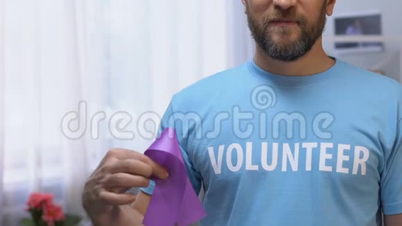 男性志愿者持有紫丝带癫痫和胰腺癌意识视频的预览图