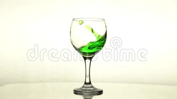 酒杯中的绿色液体飞溅视频的预览图