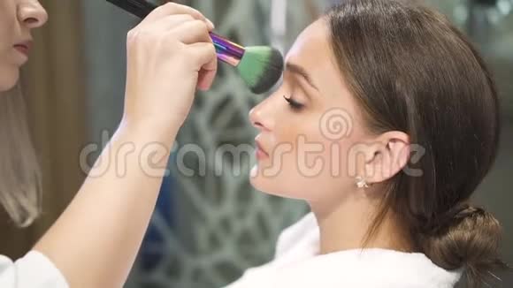 在年轻女士脸上化妆的过程视频的预览图