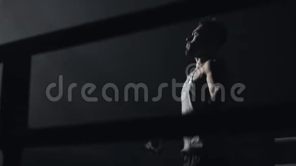 男拳击手裹着绷带跳在跳绳的暗环上慢动作剪影拳击概念视频的预览图