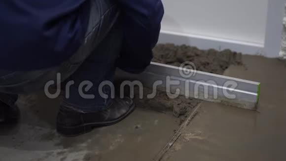 公寓和房屋的修缮建筑工人将水泥洒在地板上并将其找平视频的预览图