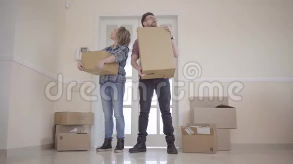 一对年轻夫妇搬进了一个新家一对夫妇站在门口手里拿着箱子美丽美丽视频的预览图