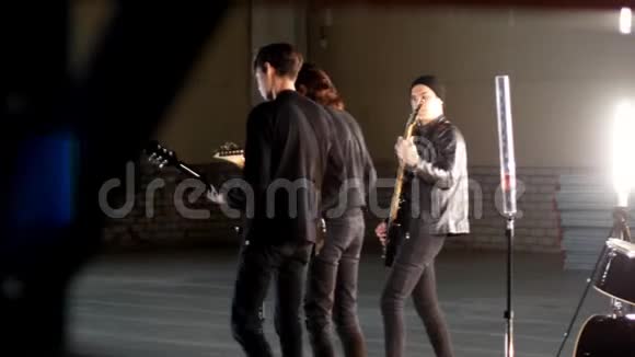 一个年轻的摇滚团体有重复穿着黑色衣服的吉他手在演奏他们的部分视频的预览图