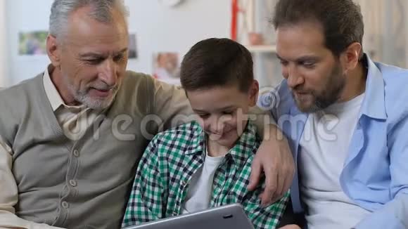 家庭一起使用平板电脑给小男孩的生日礼物一代人视频的预览图