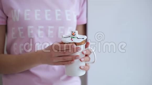 穿着粉红色T恤的年轻女子喜欢在家喝带冬饼的茶视频的预览图