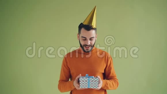 生日快乐的人戴着派对帽手里拿着礼品盒和微笑的画像视频的预览图