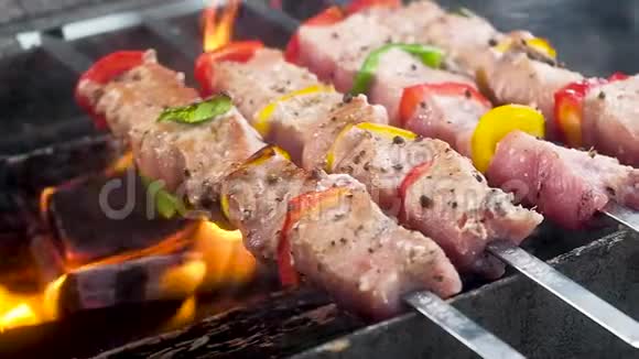 猪肉和胡椒串在串上撒上香料和胡椒正在准备热煤火焰和烟雾果汁视频的预览图